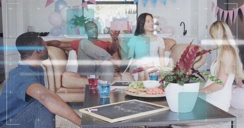Friends chatting in cozy living room party with snacks, balloons and festive bunting