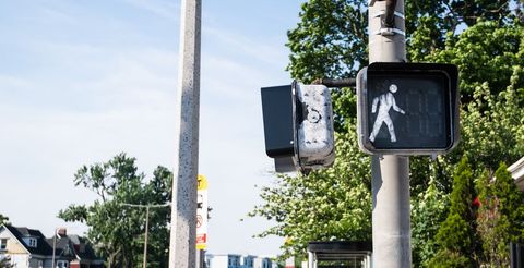 Urban pedestrian crossing signal displaying walk symbol