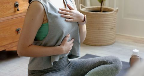 Woman Practicing Mindful Breathing at Home in Sportswear