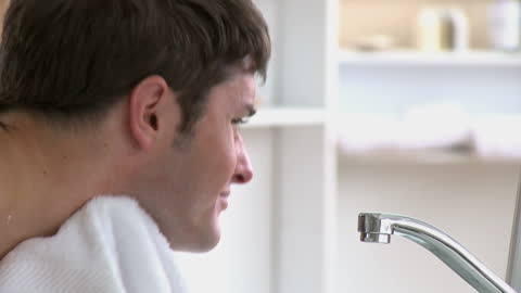 Man Refreshing After Shaving in Modern Bathroom