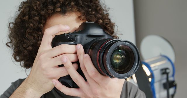 Young Photographer Capturing Focused Shots with Professional DSLR - Download Free Stock Images Pikwizard.com