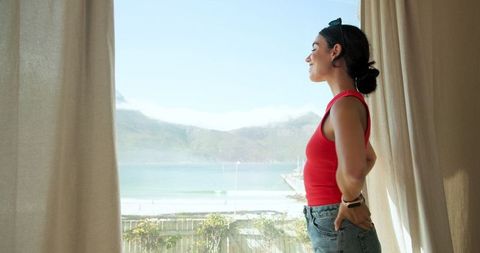 Woman Admiring Seaside View from Modern Home Interior