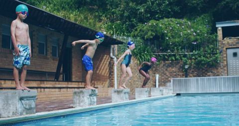 Children ready to dive at outdoor pool for aquatic sport