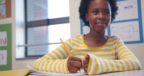 Confident african american student writing in classroom setting