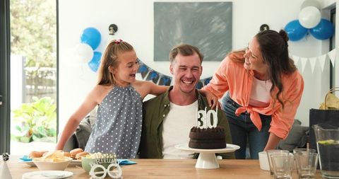 Family celebrating father's milestone birthday with joyful enthusiasm
