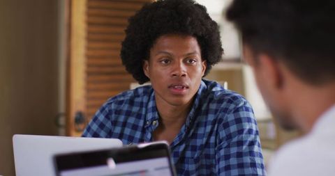 Two Diverse Male Friends Discussing Work Over Laptop in Kitchen