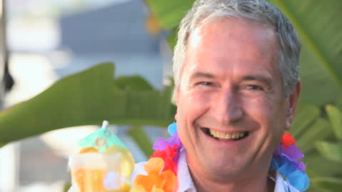 Elderly Man Enjoying a Tropical Drink with Lei in Garden