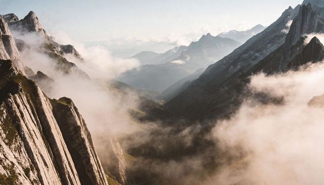 Misty Alpine Valley with Striated Cliffs, Low Clouds and Dramatic Ridgelines