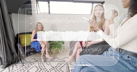 Women Collaborating in Casual Living Room Meeting with Digital HUD Data Visuals Overlay