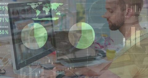 Businessman analyzing data on computer with world map overlay