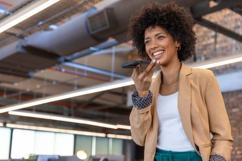 Businesswoman with Afro Hair Speaking on Smartphone in Modern Office Environment