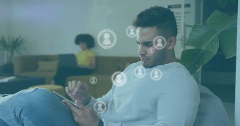Casual businessman using smartphone with digital media icons in office