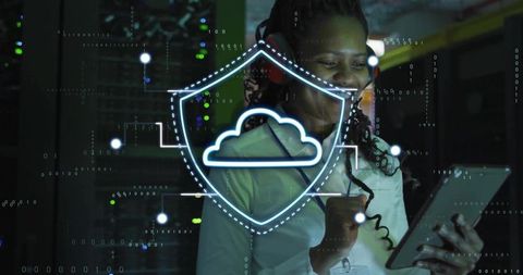 Female it technician monitoring cloud security in neon data center using tablet and headset
