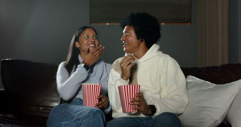 Interracial Couple Enjoying Popcorn on Cozy Couch