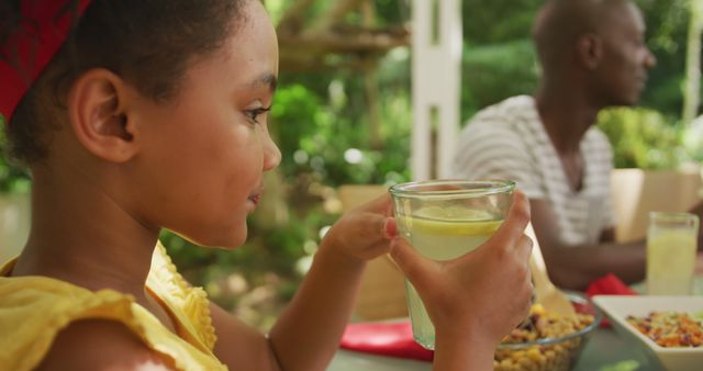 Young girl drinking lemonade at family picnic outdoors - Download Free Stock Images Pikwizard.com