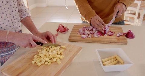 Chopping vegetables in kitchen for cozy home-cooked meal preparation