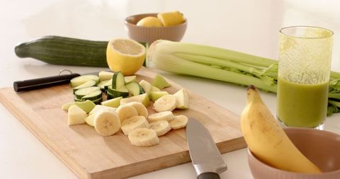 Fresh Ingredients and Green Smoothie Preparation in Modern Kitchen