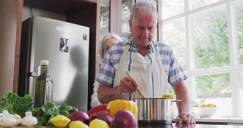 Elderly Couple Joyfully Cooking Together in Sunny Kitchen