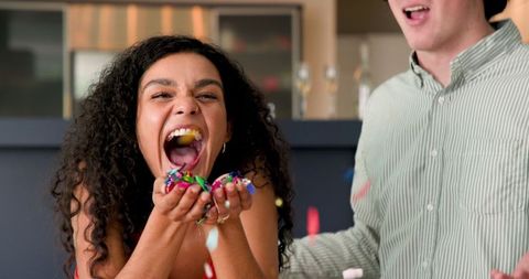 Couple celebrates in living room with confetti and laughter