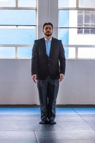 Businessman in formal suit exercises in training gym