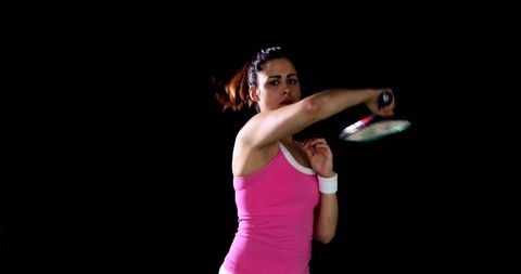 Woman in pink sportswear warming up with racquet