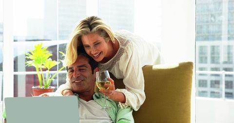 Couple Relaxing with Laptop and Wine at Home