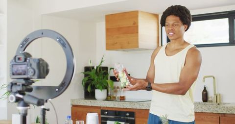 African american man filming healthy cooking vlog at home kitchen