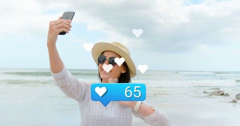 Woman Taking Selfie on Beach with Social Media Reactions Overlay