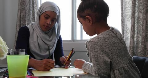 Mother with Hijab Bonding with Daughter During Art Activity