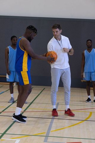 Diverse Coach Training Players on Basketball Court