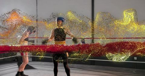 Sparring boxer in blue headgear with gold particle motion trail in boxing ring