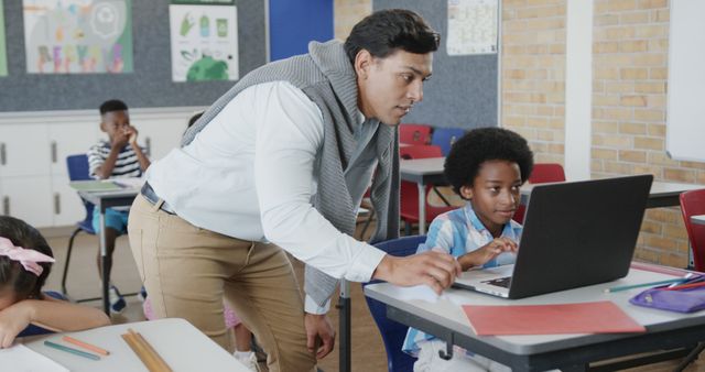 Teacher Assisting Student on Laptop in Classroom - Download Free Stock Images Pikwizard.com