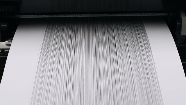 Industrial wide-format plotter printing monochrome vertical stripes on continuous paper