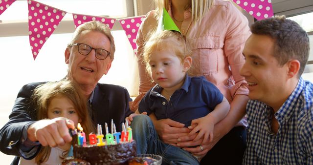Grandfather lighting candles on birthday cake - Download Free Stock Photos Pikwizard.com