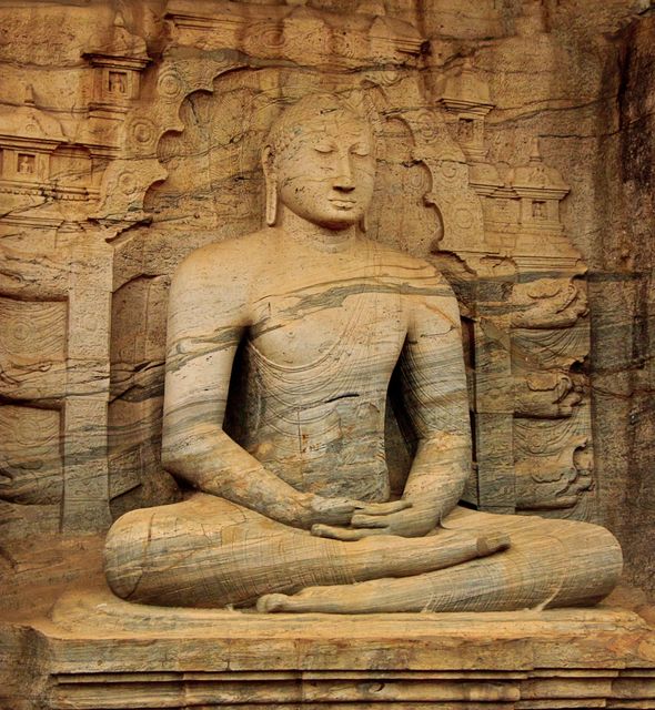 The image shows an ancient rock-carved Buddha statue, deeply embodying peace and serenity in a meditation pose. Suitable for use in historical, cultural, and archaeological discussions, as well as in topics surrounding Buddhism and spirituality. Can be utilized for educational purposes, travel guides, and articles on ancient art and heritage conservation.