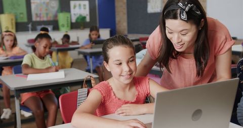 Female Teacher Assisting Students with Laptops in Classroom - Download Free Stock Images Pikwizard.com