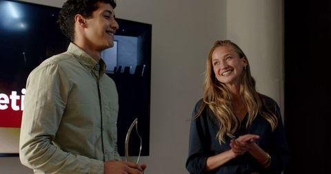 Young Professionals Celebrating Success at Office Presentation