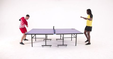 Diverse athletes intensively playing table tennis indoors