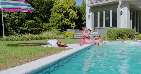 Friends Relaxing at Home Poolside Using Smartphone