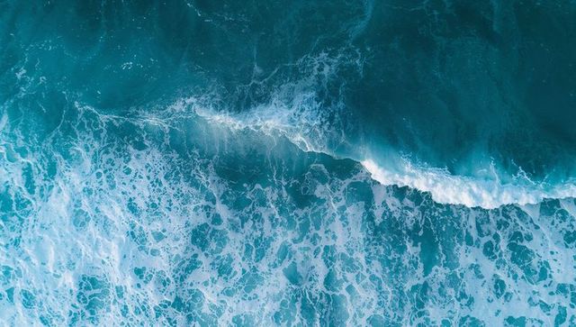 Dynamic aerial view of ocean wave with turquoise hues