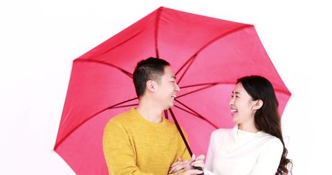Joyful Couple Laughing Under Red Umbrella - Download Free Stock Images Pikwizard.com