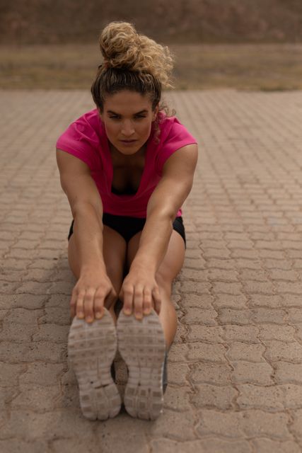 Caucasian Woman Stretching Legs Outdoors in Pink T-Shirt - Download Free Stock Images Pikwizard.com