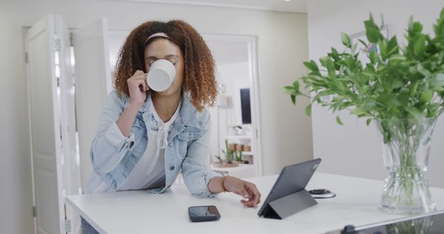 Businesswoman drinking coffee while taking phone call in home office - Download Free Stock Images Pikwizard.com