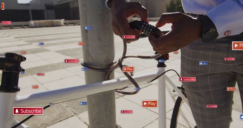 Man Securing Bicycle with Digital Symbols in Urban Plaza