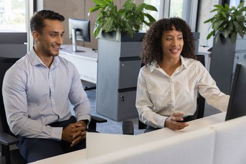 Diverse team collaborating at shared desk in modern workspace