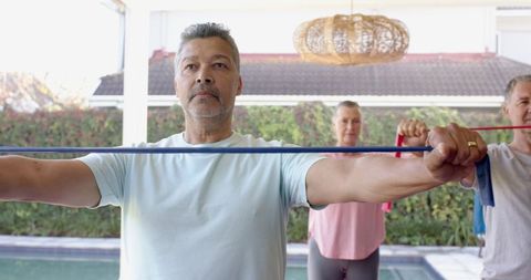 Active seniors engaging in resistance band exercises at outdoor patio