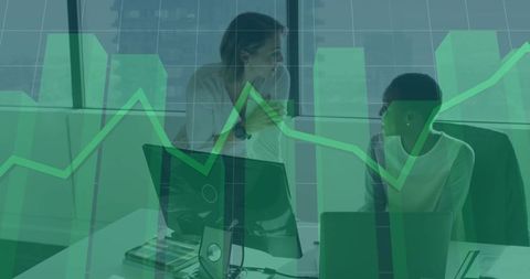 Female colleagues collaborating and analyzing data in modern office