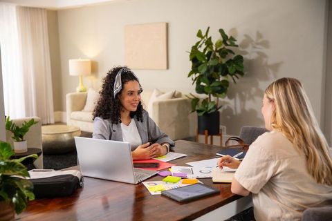 Two diverse female coworkers collaborating on business strategy at home