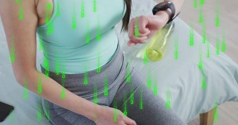 Checking smartwatch while holding water bottle with digital fitness data overlay