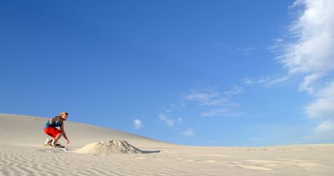 Adventurous Young Man Sandboarding on Scenic Desert Dune - Download Free Stock Images Pikwizard.com